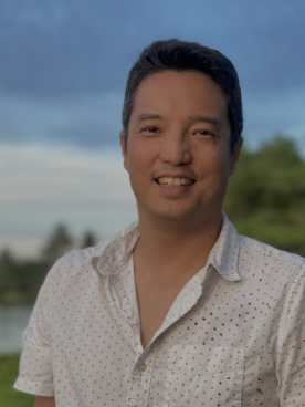 Portrait of Peter Chaibongsai outdoors with the ocean in the background