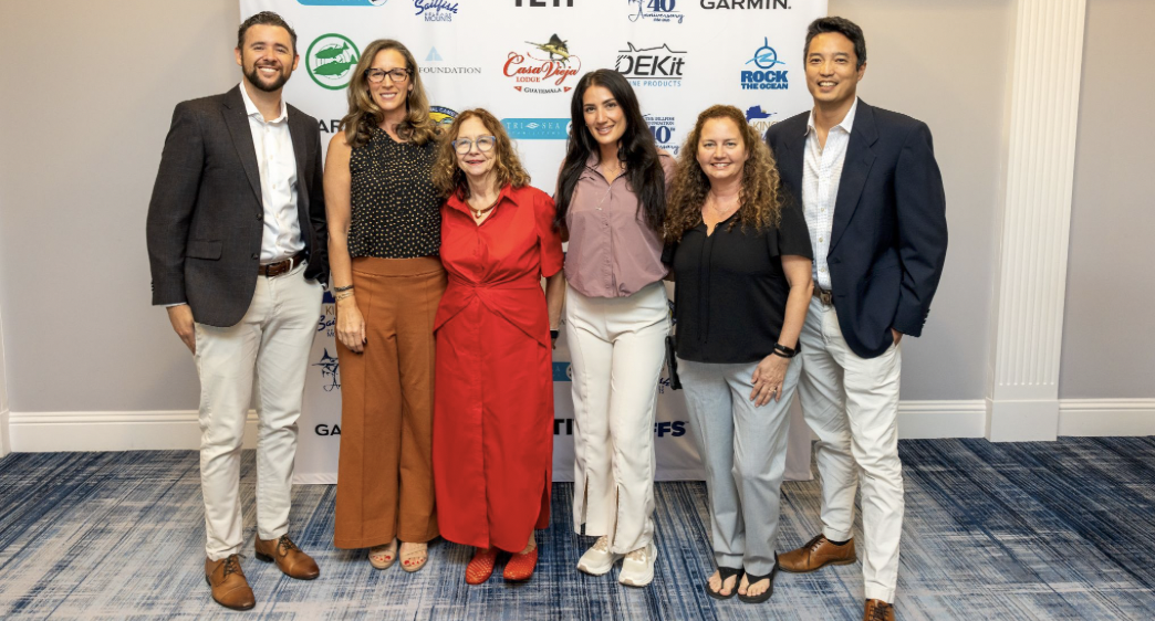 Six attendees posing in front of The Billfish Foundation sponsor backdrop